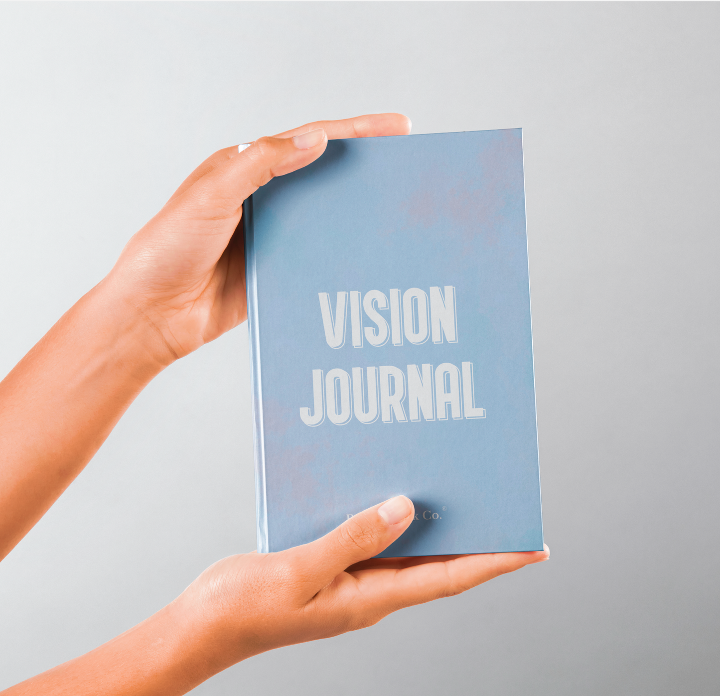 Person holding the SelfWork Co. Vision Journal hardcover with clean blue cover and minimalist branding