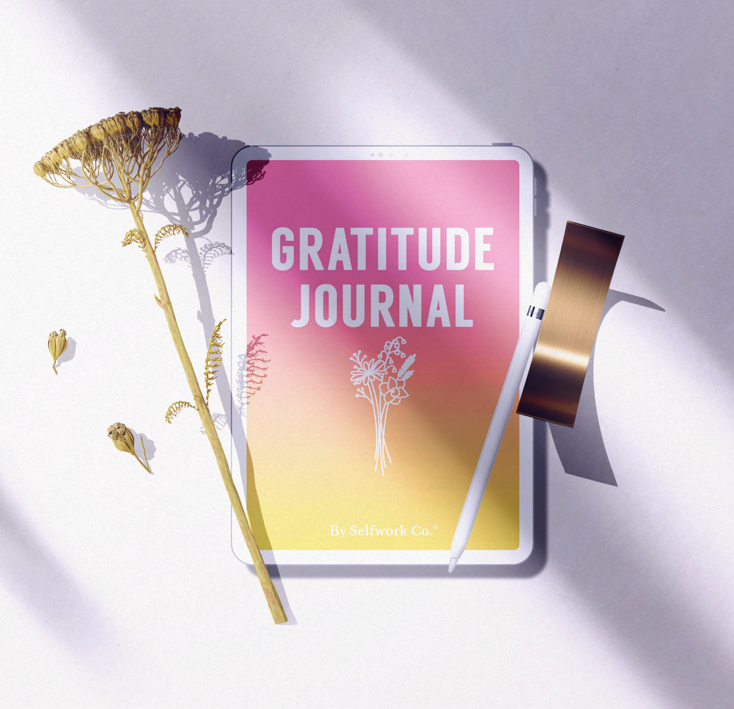 Flat lay of SelfWork Co. Gratitude Journal digital version with stylus, dried flowers, and natural light shadows