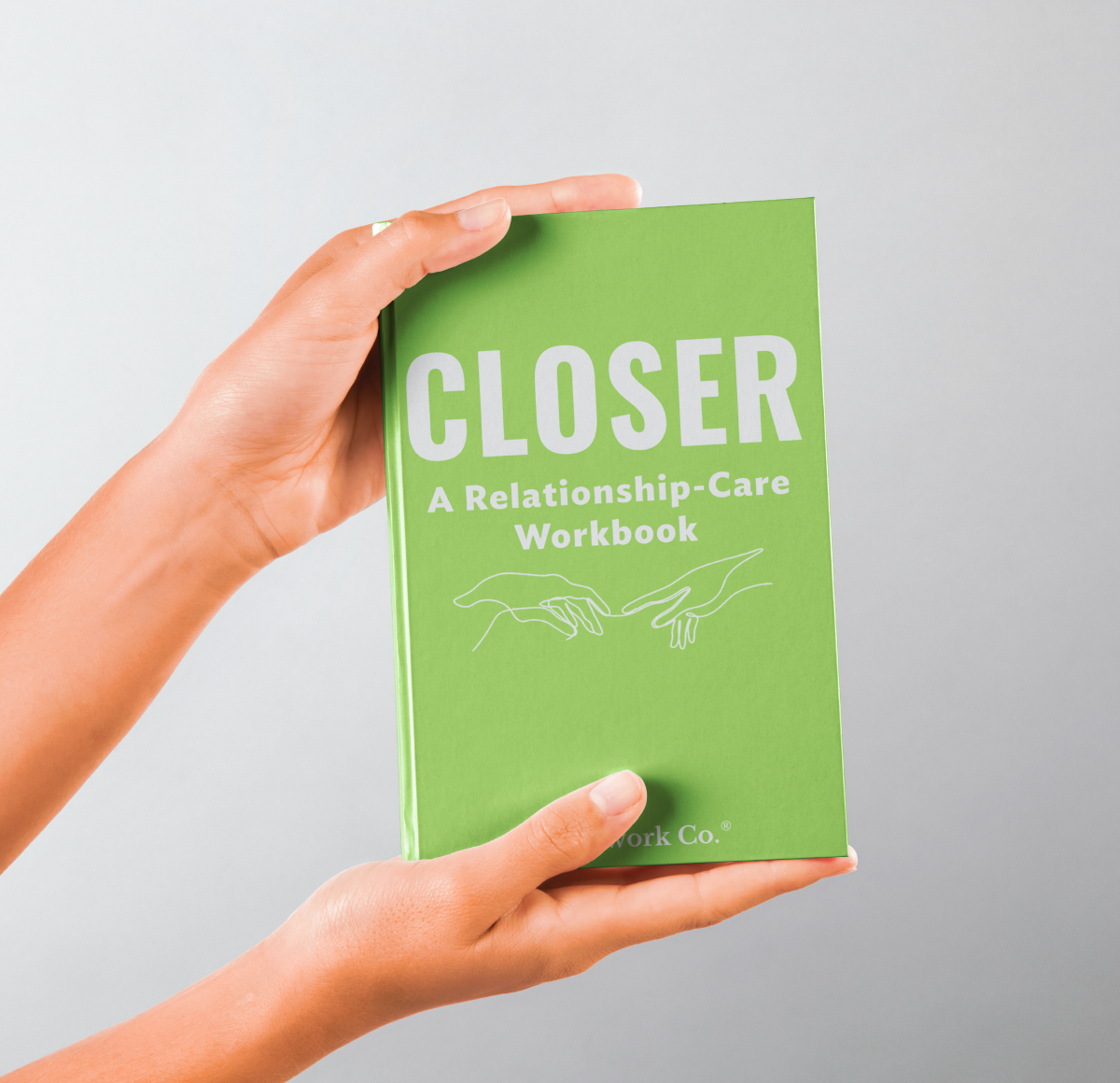 Person holding the Closer Relationship-Care Workbook hardcover in hand, showcasing its compact, vibrant green design.

