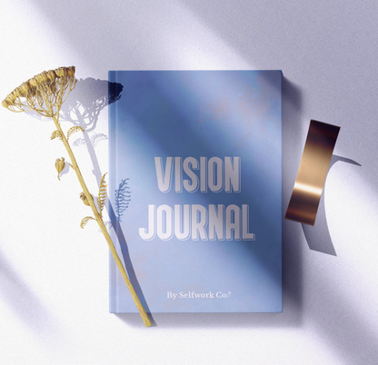 Flat lay of SelfWork Co. Vision Journal hardcover with natural lighting, dried flowers, and ribbon props