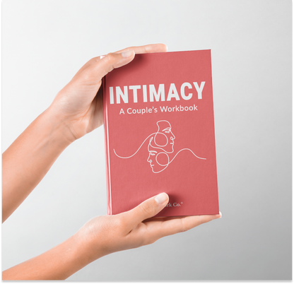 Book titled 'Intimacy: A Couple's Workbook' held by a hand on a light gray background