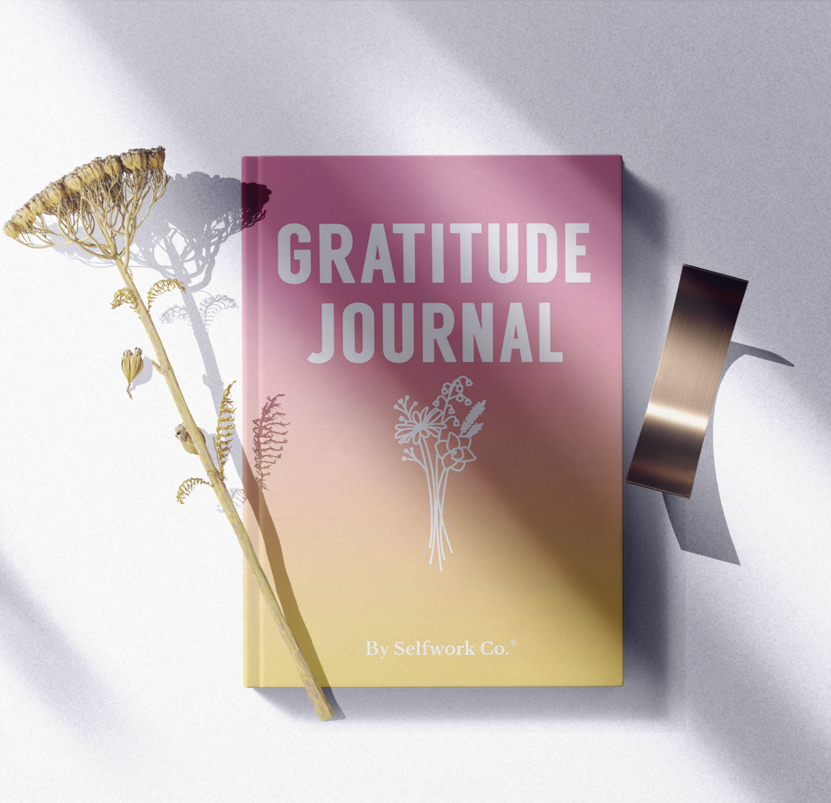 Gratitude Journal hardcover book in a styled flatlay with shadows and props