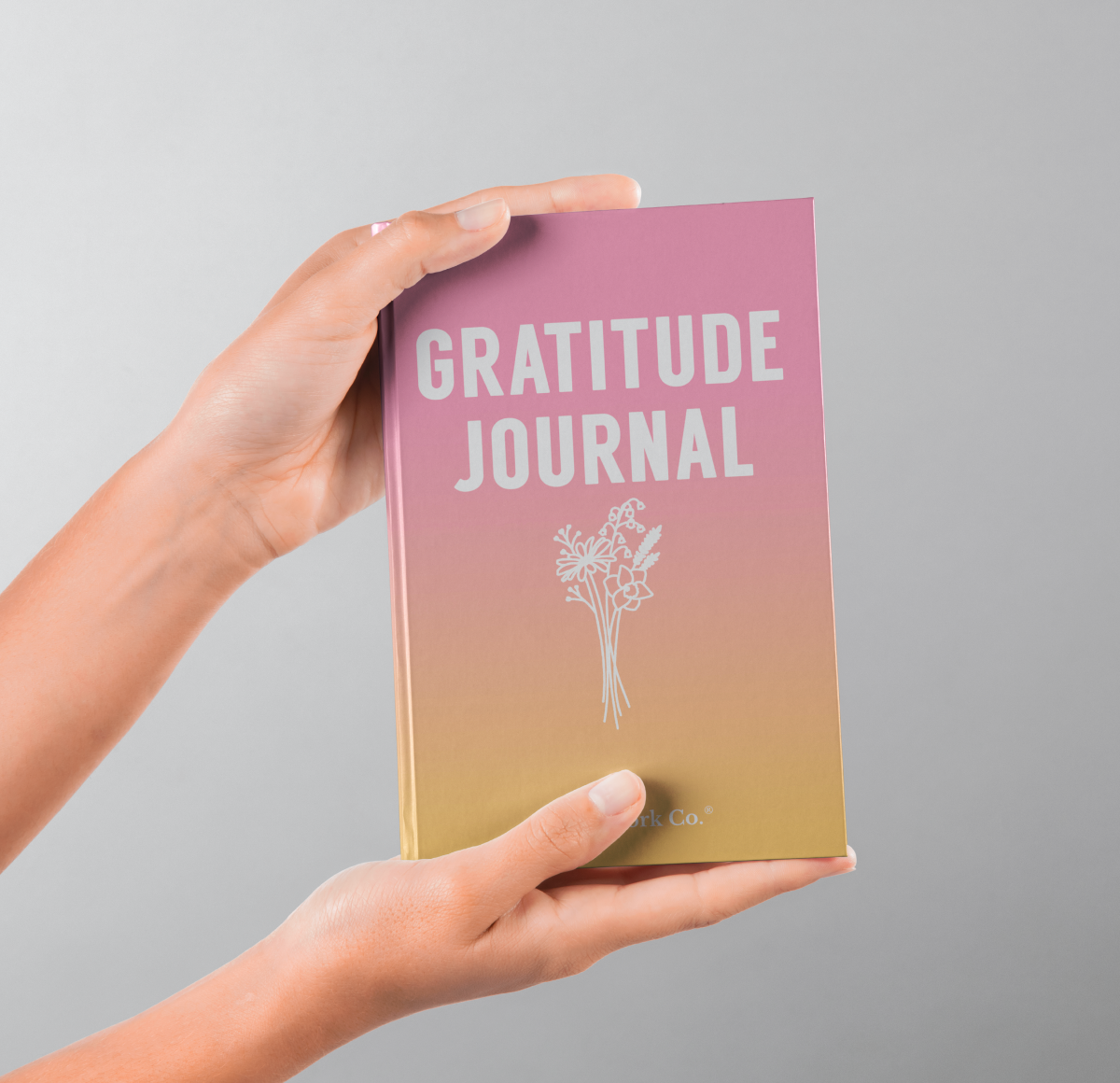 Person holding Gratitude Journal hardcover book, showcasing cover and physical feel