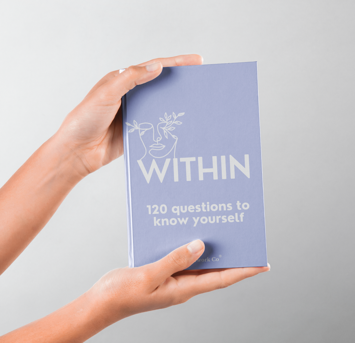 Person holding Within hardcover journal to highlight texture and size